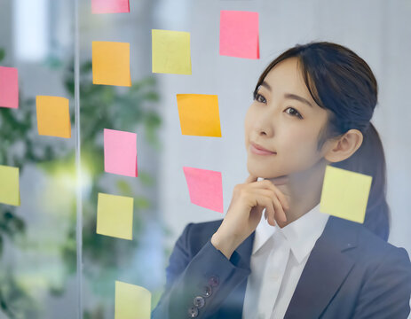 付箋を見る事務員の女性