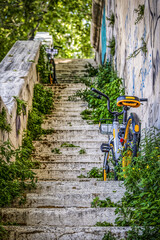 Vélo de location posé contre un mur de graffitis sur un escalier