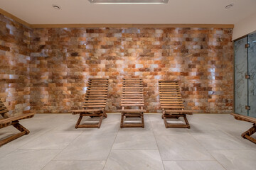 interior of modern wellness salt haloper cave with uv light with wooden sunbed benches
