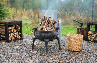Fire pit and burning fire in a garden - obrazy, fototapety, plakaty