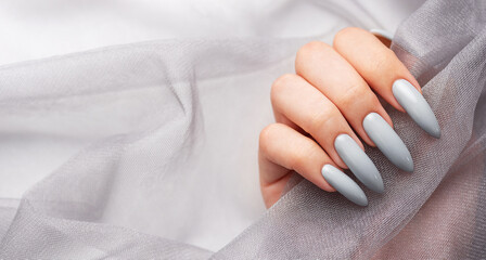 Grey nails on grey lace background.