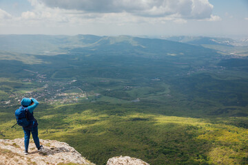 Fototapeta na wymiar Traveler on top of mountain looking at landscape on hike