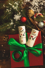 Marshlellow snowmen in a mug. Hot chocolate with marshmallows. Christmas mood. Funny and cute snowmen in a coffee mug. Warm and cozy autumn. Close-up of the Christmas composition.