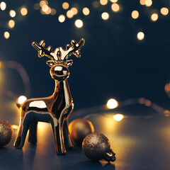 Christmas golden deer with decorations on dark background