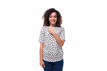 portrait of a slim young stylish woman with a curly haircut dressed in a blouse with polka dots