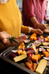 Midsection of senior caucasian couple preparing vegetables, seasoning with rosemary, copy space