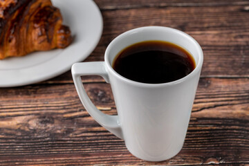 Relaxing americano coffee in black porcelain cup on wooden table