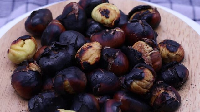 Fresh roasted chestnuts rotating on a turntable.