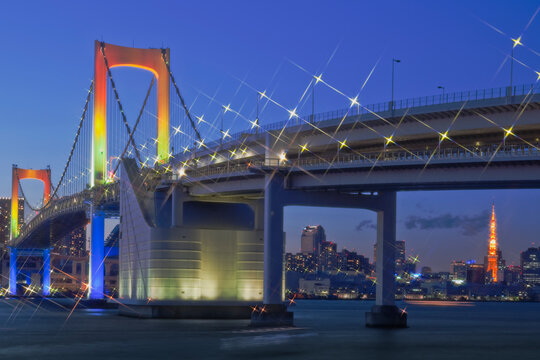 Sunset view of the illuminated Rainbow Bridge and buildings , Odaiba,Minato,Tokyo,Japan December 2010