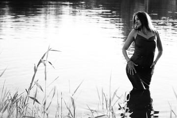 Happy blonde woman having fun in sunny park smiling, fooling around, laughing. Slow Motion. Beautiful caucasian girl dancing under the summer rain. wet hair and clothes. enjoying with drops.