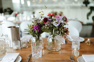 Colorful flowers in a transparent glass vase at a wedding loaction