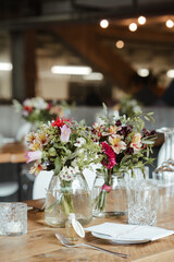 Colorful flowers in a transparent glass vase at a wedding loaction