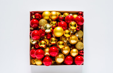Red and golden baubles put in the box on white background. Christmas holiday concept.