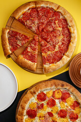traditional Italian pizza with salami and vegetables on a black