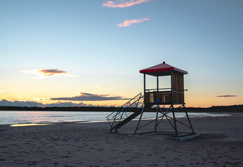 view of a lifeguard deck on the shore of the sea at sunset time