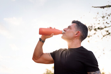 man drinking water during her training, concept of sport in nature and healthy lifestyle, copy space for text