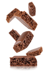 Levitation of cubes of milk porous chocolate isolated on a transparent background.