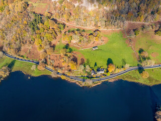 Aerial image of Rydal water lake in the lake district national park and the lake side road , United kingdom on a beautiful autumn day. 
