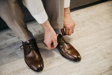The man wears brown leather shoes