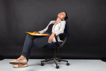 Exhausted and worried young female model in casual wear wearing white jacket, black top and black...