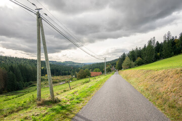 Route de campagne au milieu des collines et lignes &eacute;lectriques