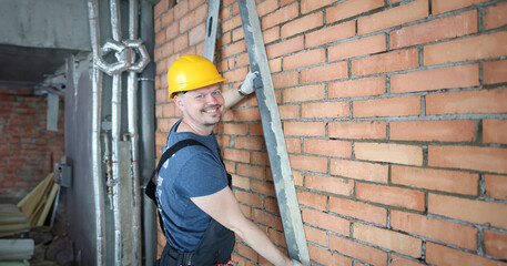 Portrait of man using special construction equipment to remove any concrete masses to make wall...