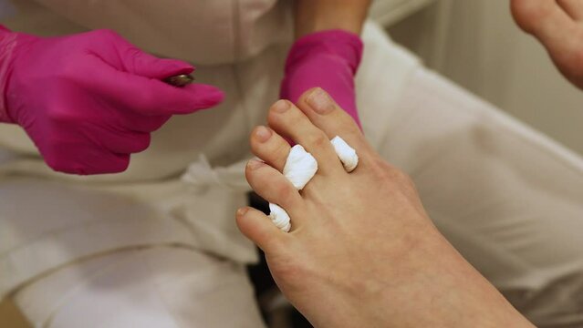 
Woman legs In a Spa Salon Receiving Classical Pedicure, cutting of cuticle nails of feet. Legs And Nail Skin Care. Pedicure Procedures And SPA process. Close up, Selective Focus.