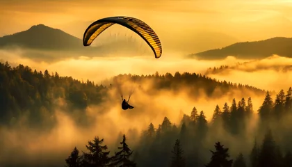 Poster Im Rahmen Orange and black paraglider flying in a beautiful mountain landscape at sunset or sunrise. Fantasy landscape, valley with fog and pine forest. © Alberto Masnovo