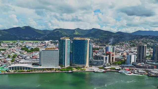 Timelapse aerial view of the city of Port of Spain, Trinidad and Tobago with a mountain range in the background