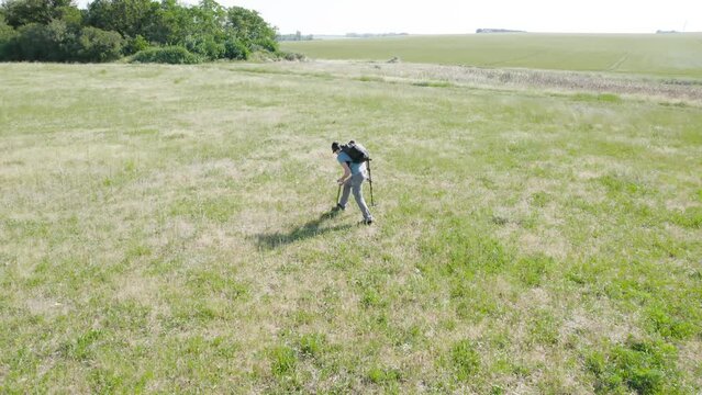 Aerial View Of Man Finding Treasure In The Field Using Metal Detector.