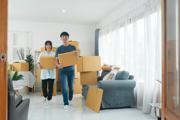 Fototapeta na wymiar Asian young happy new married couple moving to their new house or real estate.