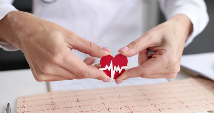 Doctor cardiologist holds heart icon in hands. Cardiology services and healthy heart concept