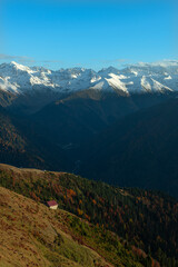 Naklejka premium Snowy mountains and white clouds in the blue sky. Snowy mountain view from Huser Plateau. Rize, Türkiye.
