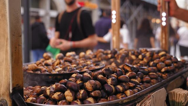 Famous Cheapest Turkish Street Food. grilled roasted chestnuts in trolley in Istanbul. Macro photography. Seller frying and selling in bag in tourist place.