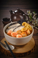 traditional chinese seafood prawn fish maw scallop seaweed thick soup Peng cai in hot clay pot on grey vintage background asian cafe hotel luxury halal food restaurant banquet menu