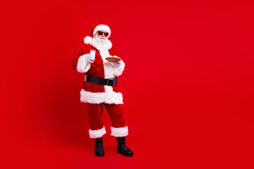 Full length photo of charismatic santa hands hold christmas glass mil cookie plate empty space isolated on red color background