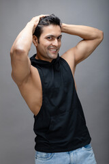 Indian young male model in casual wear wearing black tshirt and blue torn denim jeans. Male model. Fashion Portrait.