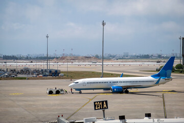 The airplane stands at the airport at sunset. The plane is preparing to take off.