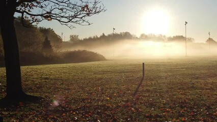 Aerial view misty morning autumn rugby pitch during vibrant golden colourful glowing sunrise