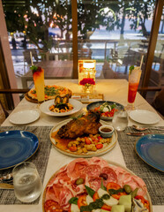 dinner table in an Italian restaurant in Thailand, antipasti with roasted pork and pizza