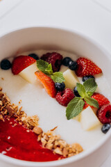 Sweet milk semolina porridge with strawberries on beautiful plate. Delicious breakfast for children