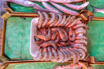 Fish shop, big prawns on a tray.