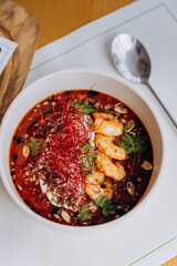 Appetizing Thai food of pumpkin porridge with shrimps served with greens and seeds in restaurant