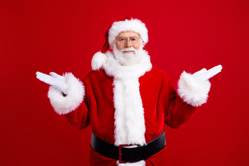 Photo of funky pensioner wear santa claus costume showing gesture dont know answer isolated on red color background