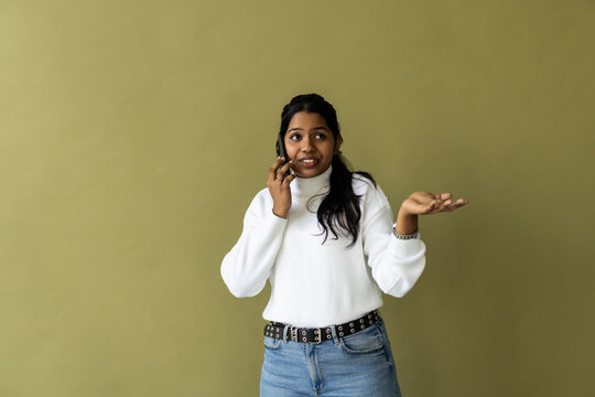 Indian woman talking on cellphone on green background