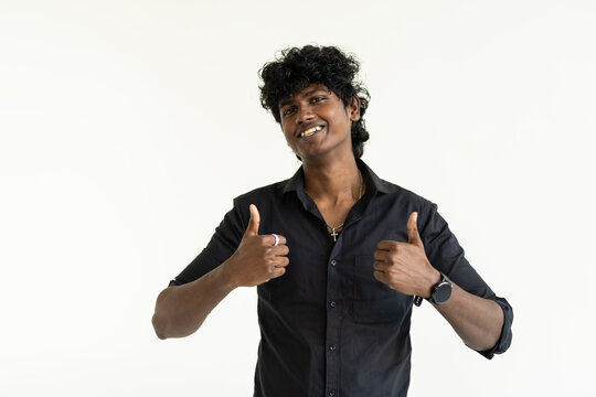 Young indian man standing over isolated white background doing happy thumbs up gesture with hand.