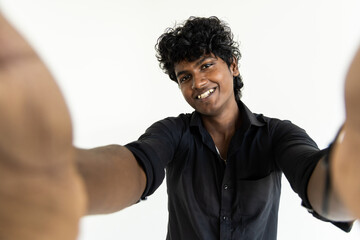 Indian young man taking selfie using smartphone, isolated over white background
