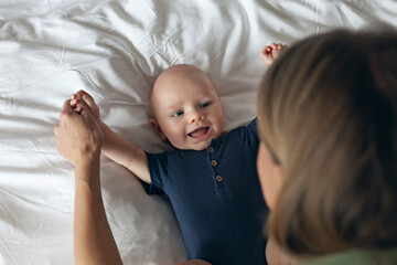 Happy smiling 3 month baby boy looking at his mother