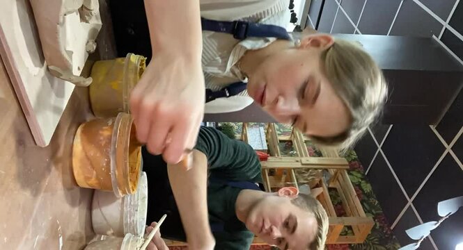 A couple of young people on a date to create mugs from clay. Time lapse. clay modeling process Vertical video.