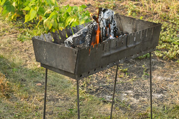 there is firewood burning in the barbecue for barbecue